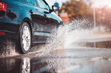 Auto rijdt in de regen